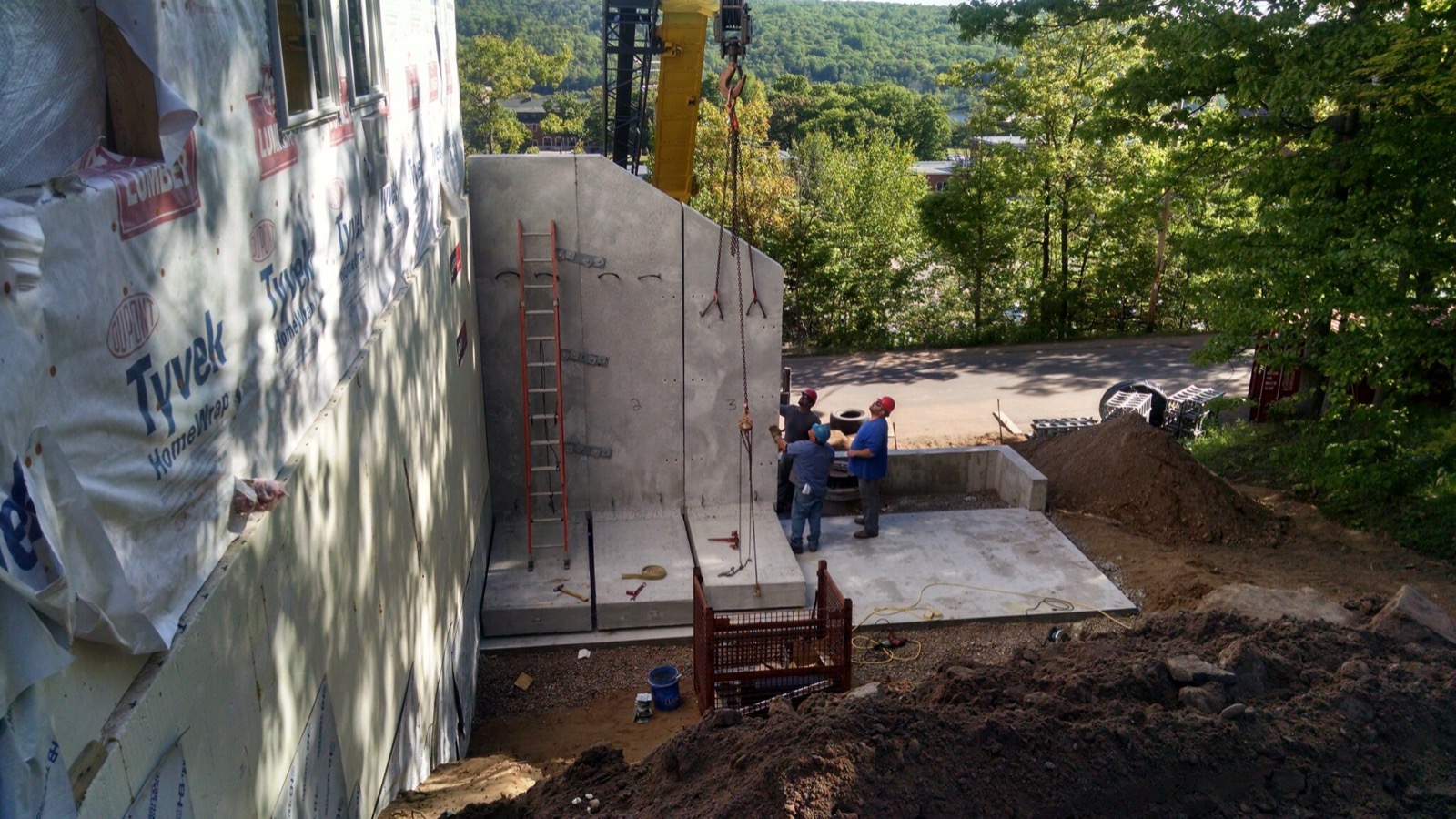 An LJJ crew setting precast concrete wall panels with a crane
